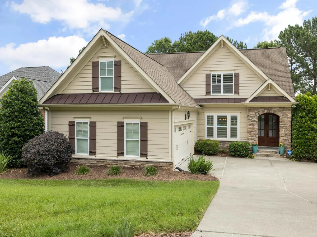 A beige ranch with a stone entry and fresh dark shingles.